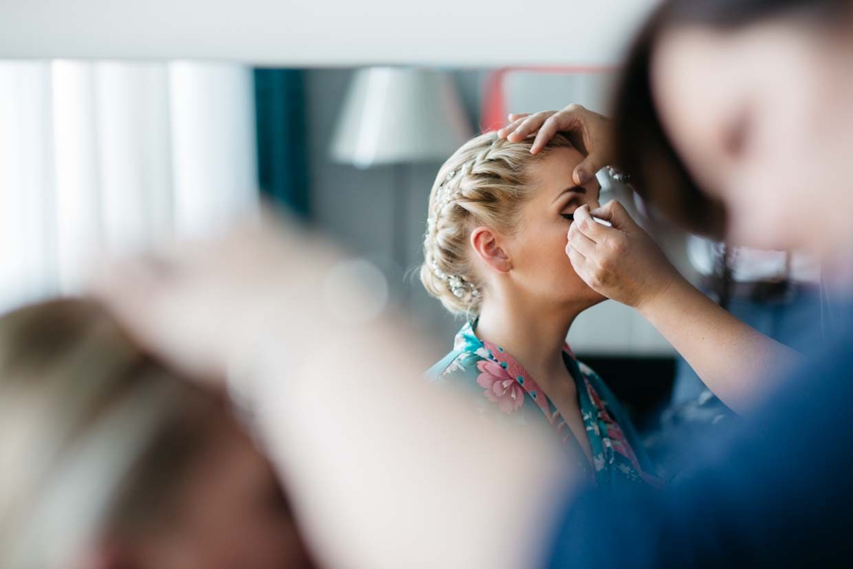 Braut werden Wimpern beim Getting Ready geschminkt
